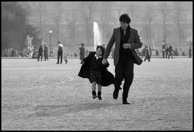 A Wednesday with papa, Paris. A father and daughter run through the Tuileries Gardens in Paris on a Wednesday afternoon when French children have the afternoon off from school. It is always a day when the Paris parks are full of wonderful scenes of parents and grandparents with their children. 1980ties. (Photo and comment by Peter Turnley)