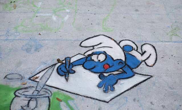 The beginnings of a Smurf-themed chalk drawing takes shape on Saturday. (Photo by Thomas Cordy/The Palm Beach Post)