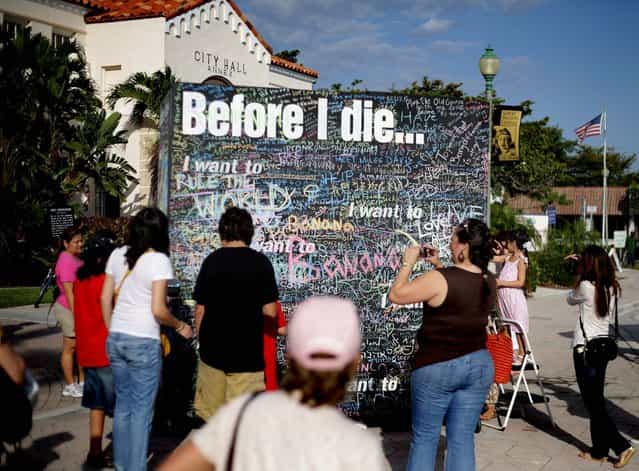 Hundreds of sentiments were scribbled on a [Before I die...] chalkboard at the festival on Saturday. (Photo by Thomas Cordy/The Palm Beach Post)