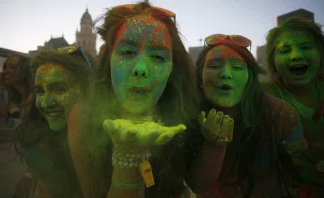Revellers blow coloured cornflour powder as they take part in the Holi One festival in Cape Town, March 2, 2013. The event is inspired by the Hindu Holi spring festival of colour which originated in India. (Photo by Mark Wessels/Reuters)