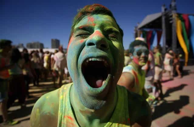 A reveller reacts as he is covered in coloured cornflour powder while participating in the Holi One festival in Cape Town, March 2, 2013. The event is inspired by the Hindu Holi spring festival of colour which originated in India. (Photo by Mark Wessels/Reuters)