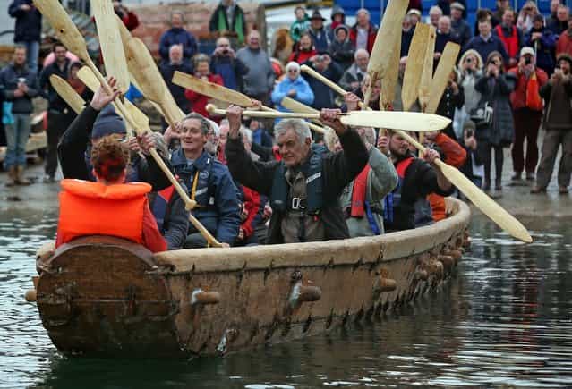 Crew in Britain's first ever full-size reconstructed sea-going Bronze Age boat, raise their paddles out as it makes its maiden voyage on March 6, 2013 in Falmouth, England. With a crew of of 18, equipped with Bronze-Age-style wooden paddles, the 15 metre long experimental vessel – a replica of the sort of craft used for long-distance trade between Britain and the continent 4000 years ago – will be used to test prehistoric seafaring methods in a project in collaboration with the University of Exeter and the Falmouth-based National Maritime Museum Cornwall. (Photo by Matt Cardy)