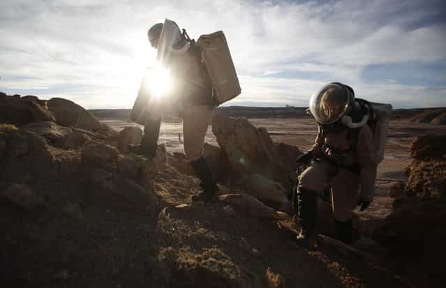 Melissa Battler (L), a geologist and commander of the Crew 125 EuroMoonMars B mission, and Csilla Orgel, a geologist, climb a rock formation to collect geologic samples for study at the Mars Desert Research Station (MDRS) in the Utah desert March 2, 2013. The MDRS aims to investigate the feasibility of a human exploration of Mars and uses the Utah desert's Mars-like terrain to simulate working conditions on the red planet. Scientists, students and enthusiasts work together developing field tactics and studying the terrain. All outdoor exploration is done wearing simulated spacesuits and carrying air supply packs and crews live together in a small communication base with limited amounts of electricity, food, oxygen and water. Everything needed to survive must be produced, fixed and replaced on site. (Photo by Jim Urquhart/Reuters)