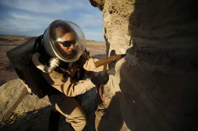 Melissa Battler, a geologist and commander of Crew 125 EuroMoonMars B mission, collects geologic samples for study at the Mars Desert Research Station (MDRS) in the Utah desert March 2, 2013. The MDRS aims to investigate the feasibility of a human exploration of Mars and uses the Utah desert's Mars-like terrain to simulate working conditions on the red planet. Scientists, students and enthusiasts work together developing field tactics and studying the terrain. All outdoor exploration is done wearing simulated spacesuits and carrying air supply packs and crews live together in a small communication base with limited amounts of electricity, food, oxygen and water. Everything needed to survive must be produced, fixed and replaced on site. (Photo by Jim Urquhart/Reuters)