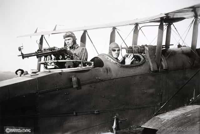 Two men at guns mounted in their airplane, photographed in 1920 by Harris & Ewing.