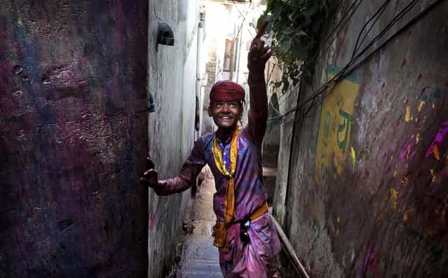 A young villager from Nandgaon, soaked in water and colors, arrives in Barsana. (Photo by Manish Swarup/Associated Press)