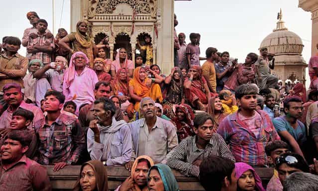 Hindu devotees wait outside the Ladali or Radha temple during the Lathmar Holi festival in Barsana. (Photo by Manish Swarup/Associated Press)