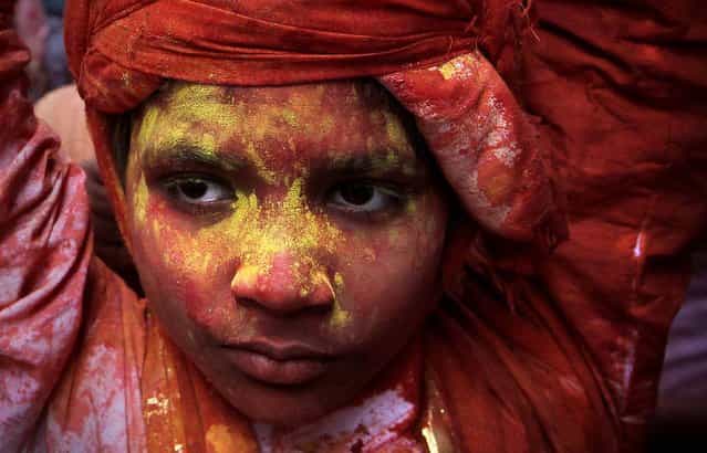 A young villager from Nandgaon is soaked in water and colored powder. (Photo by Manish Swarup/Associated Press)