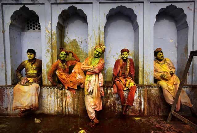 Villagers from Nandgaon wait for the arrival of villagers from Barsana to play Lathmar Holi at the Nandagram temple famous for Lord Krishna and his brother Balram, in Nandgaon, India, on Friday, on March 22, 2013. (Photo by Manish Swarup/Associated Press)