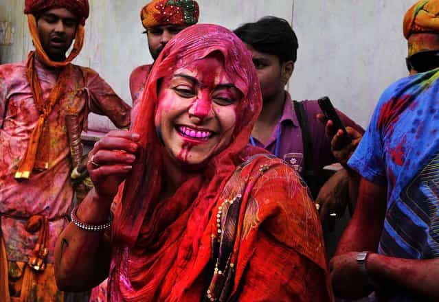 Devotees smeared with colors watch others dance and play at the Nandagram temple, on March 22, 2013. (Photo by Manish Swarup/Associated Press)
