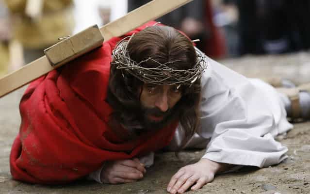 A man playing the role of Jesus carries a cross to the Church of the Holy Sepulchre on Good Friday during Holy Week, in the north of Poland March 29, 2013. (Photo by Kacper Pempel/Reuters)