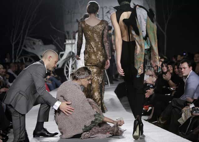 A model is helped by a spectator after she fell while presenting a creation by Georgian designer Irakli Nasidze during Georgian Fashion Week in Tbilisi March 26, 2010. Twenty-one designers and fashion houses participated in the first ever Georgian Fashion Week. (Photo by David Mdzinarishvili/Reuters)