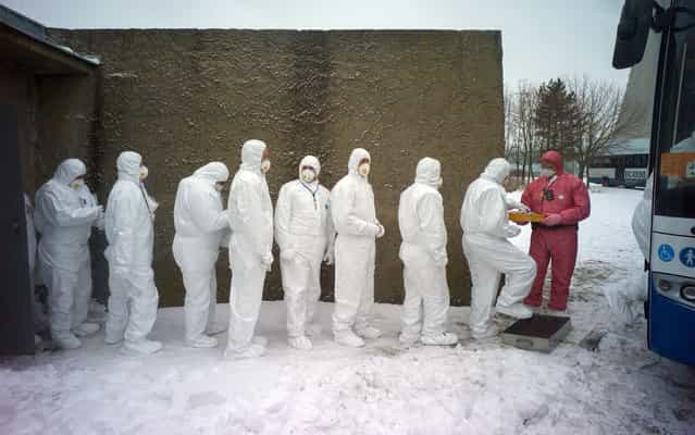 Workers of Dukovany nuclear power plant dressed in radiation protection suits get on a bus during a nuclear accident exercise on March 26, 2013 in Dukovany nuclear power plant, 50km from the city of Brno, Czech Republic. (Photo by Michal Cizek/AFP Photo)
