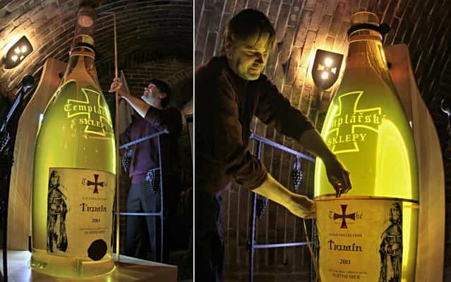 A representative of the Czech Guinness Book of Records measures a giant bottle of wine in Cejkovice, southern Czech Repubic, on March 28, 2013. The bottle, which is over two meters in height and contains 200 liters of wine, has being registered as the [Largest wine bottle in the Czech Republic]. (Photo by Radek Mica/AFP Photo)