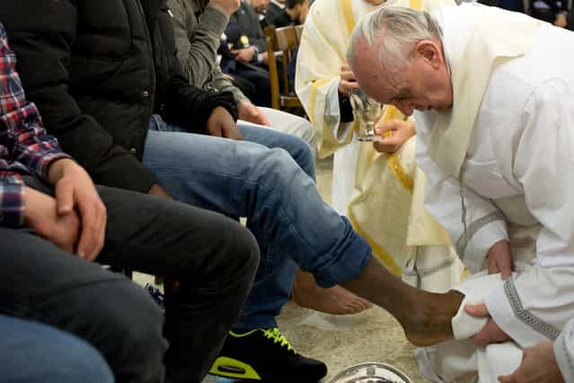 In this photo provided by the Vatican newspaper L'Osservatore Romano, Pope Francis washes the foot of an inmate at the juvenile detention center of Casal del Marmo, Rome, Thursday, March 28, 2013. Francis washed the feet of a dozen inmates at a juvenile detention center in a Holy Thursday ritual that he celebrated for years as archbishop and is continuing now that he is pope. Two of the 12 were young women, an unusual choice given that the rite re-enacts Jesus' washing of the feet of his male disciples. The Mass was held in the Casal del Marmo facility in Rome, where 46 young men and women currently are detained. Many of them are Gypsies or North African migrants, and the Vatican said the 12 selected for the rite weren't necessarily Catholic. (Photo by L'Osservatore Romano/AP Photo) In this photo provided by the Vatican newspaper L'Osservatore Romano, Pope Francis washes the foot of an inmate at the juvenile detention center of Casal del Marmo, Rome, Thursday, March 28, 2013. Francis washed the feet of a dozen inmates at a juvenile detention center in a Holy Thursday ritual that he celebrated for years as archbishop and is continuing now that he is pope. Two of the 12 were young women, an unusual choice given that the rite re-enacts Jesus' washing of the feet of his male disciples. The Mass was held in the Casal del Marmo facility in Rome, where 46 young men and women currently are detained. Many of them are Gypsies or North African migrants, and the Vatican said the 12 selected for the rite weren't necessarily Catholic. (Photo by L'Osservatore Romano/AP Photo)