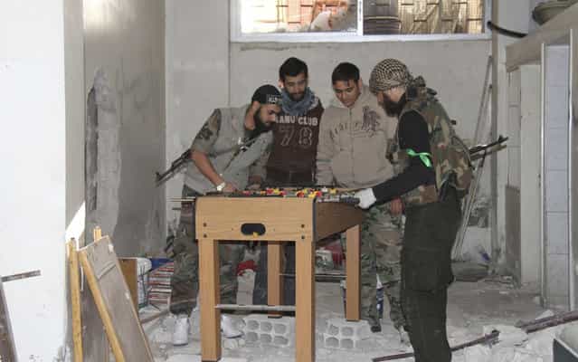 Free Syrian Army fighters play foosball in Sidi Meqdad area in the suburbs of Damascus, on March 28, 2013. (Photo by Ward Al-Keswani/Shaam News Network/Reuters)