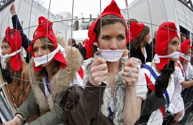 Girls dressed in costumes from the French revolution look through a fence as they take part in a protest march over France's planned legalisation of same-sex marriage in Paris March 24, 2013. (Photo by Mal Langsdon/Reuters)