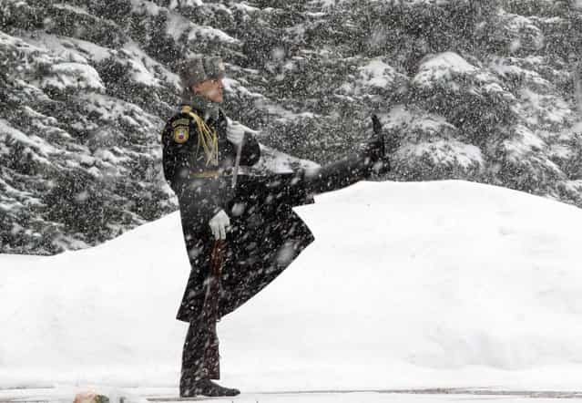 An honour guard marches during the changing of the guards ceremony at the Tomb of the Unknown Soldier by the Kremlin wall during snowfall in central Moscow, March 25, 2013. (Photo by Sergei Karpukhin/Reuters)