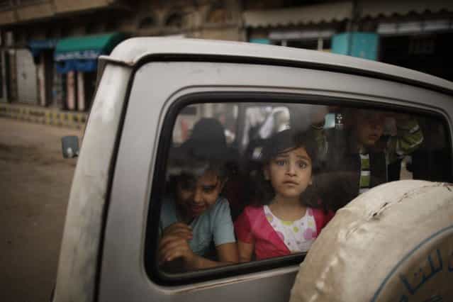 Children watch from the rear window of a car as protesters march past demanding Yemen's former President Ali Abdullah Saleh's immunity be stripped and that he stand trial for the killings of protesters who demanded the end of his 33-year rule, in Sanaa March 28, 2013. (Photo by Khaled Abdullah/Reuters)