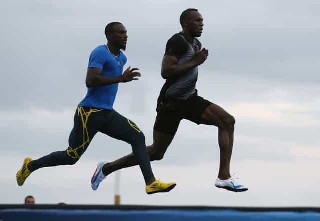 Jamaica's Olympic gold medallist Usain Bolt (R) and Antigua and Barbuda's Daniel Bailey run during a training session for the [Mano a Mano] challenge on Copacabana beach in Rio de Janeiro March 29, 2013. The [Mano a Mano]challenge will be held on March 31. (Photo by Sergio Moraes/Reuters)
