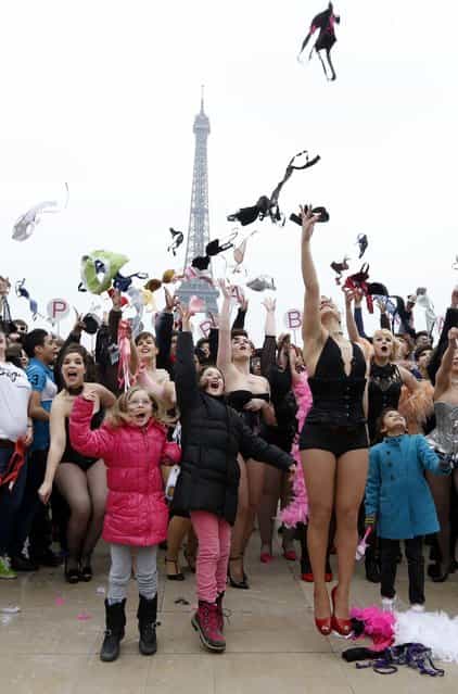 Woman throws bras on March 25, 2013 at the esplanade des droits de l'homme, in front of the Eiffel tower in Paris, during a happening called by [Pink Bra Bazzar], a French organization fighting against and sensitizing on breast cancer. (Photo by Pierre Verdy/AFP Photo)