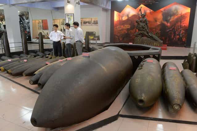Visitors look at covers of different types of bombs that were used during the Vietnam War at a Bombs and Mines Museum in Hanoi on March 25, 2013. A meeting was held by the Defense Ministry at the museum to mark the International Day of Mine Awareness and Assistance in Mine Action on April 4th. (Photo by Hoang Dinh Nam/AFP Photo)