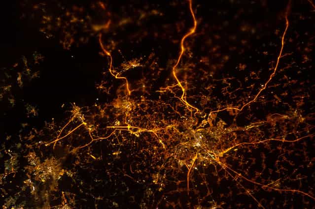 A nighttime view of Liege, Belgium, photographed by an Expedition 34 crew member on December 8, 2012. The brightly lit core of the Liege urban area appears to lie at the center of a network of roadways extending outwards into the rural, and relatively dark, Belgium countryside. For a sense of scale the distance from left to right is approximately 70 kilometers. The image was taken using the European Space Agency's Nodding mechanism, also known as the NightPod. NightPod is an electro-mechanical mount system designed to compensate digital cameras for the motion of the space station relative to Earth. The primary mission goal was to take high-resolution, long exposure digital imagery of Earth from the station's Cupola, particularly cities at night. (Photo by NASA/The Atlantic)