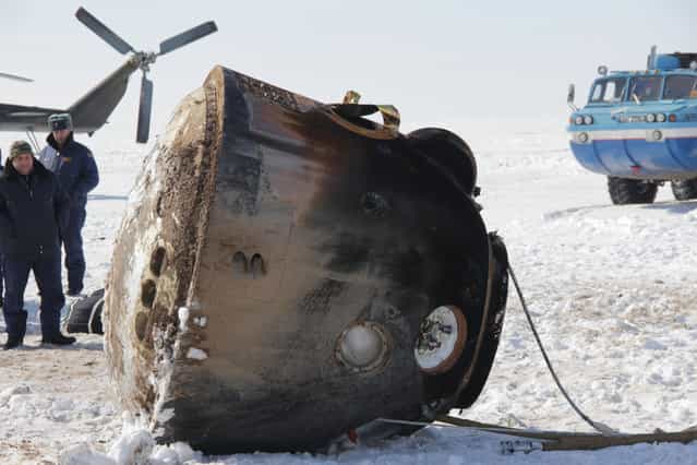 The Soyuz TMA-06M spacecraft lies passively on its side March 16 after bringing home Expedition 34 Commander Kevin Ford of NASA, Soyuz Commander Oleg Novitskiy and Flight Engineer Evgeny Tarelkin to a landing northeast of Arkalyk, Kazakhstan following a one-day delay due to inclement weather in the area. The Soyuz initially landed upright before being tilted on its side for servicing after touching down to wrap up 144 days in space and 142 days for Ford, Novitskiy and Tarelkin at the International Space Station. The three crewmembers were flown by helicopter to Kustanai, Kazakhstan en route to their homes in Houston and Star City, Russia. (Photo by Sergey Vigovskiy/NASA/The Atlantic)