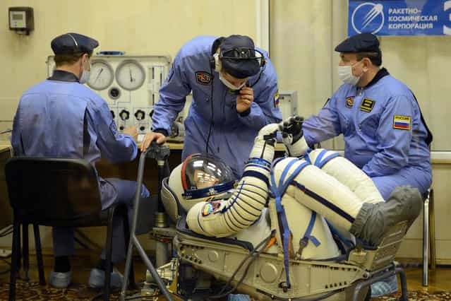 A crew member of the next expedition to the ISS, US astronaut Christopher Cassidy checks his space suit prior to the launch of the the Soyuz TMA-08M spacecraft at the Baikonur Cosmodrome, on March 28, 2013. (Photo by Ramil Sitdikov/AFP Photo/The Atlantic)