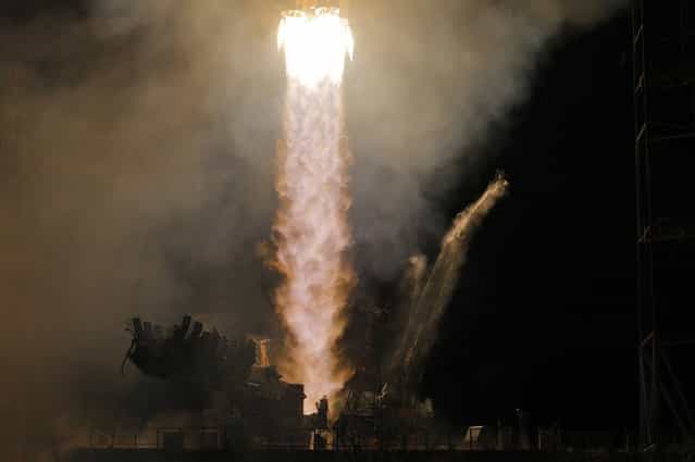 A Soyuz-FG rocket booster with the Soyuz TMA-08M space ship carrying a new crew to the ISS, blasts off from the Baikonur Cosmodrome, in Kazakhstan, on March 29, 2013. (Photo by Dmitry Lovetsky/AP Photo/The Atlantic)
