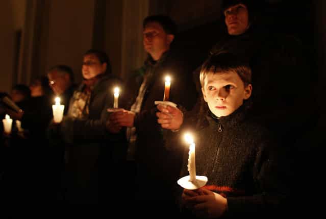 Worshippers hold candles during the Easter vigil mass in Cathedral-Basilica at the Vilnius, Lithuania, Saturday, March 30, 2013. (Photo by Mindaugas Kulbis/AP Photo)