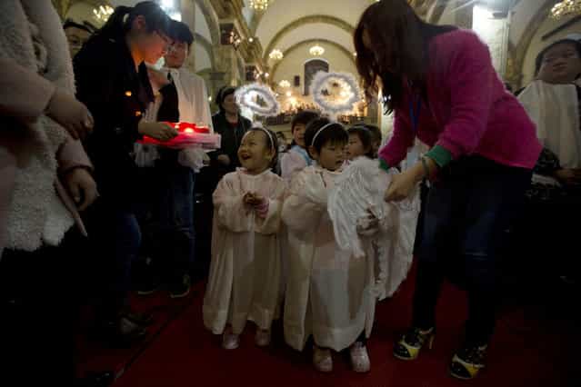 Children dressed like angels attend a ceremony on the eve of Easter Sunday at the official Catholic church South Cathedral in Beijing, China, Saturday, March 30, 2013. China and the Vatican have no diplomatic ties and the ruling Communist Party forced Chinese Catholics to sever their ties with the Holy See in the 1950s. China officially records about 6 million Catholics worshipping in 6,300 congregations across the country, although millions more are believed to worship outside the official church, with considerable crossover between the two in many areas. (Photo by Ng Han Guan/AP Photo)