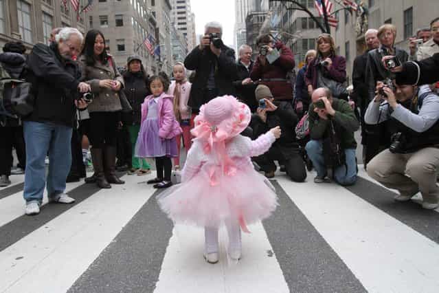 Eighteen-month-old Ariana Simmons, of New York, center, poses for photographs on New York's Fifth Avenue as she takes part in the Easter Parade Sunday March 31, 2013. (Photo by Tina Fineberg/AP Photo)