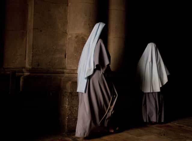 Nuns walk during the Sunday Easter mass at the Church of the Holy Sepulcher, traditionally believed to be the site of the crucifixion of Christ, in Jerusalem's Old City, Sunday, March 31, 2013. (Photo by Sebastian Scheiner/AP Photo)