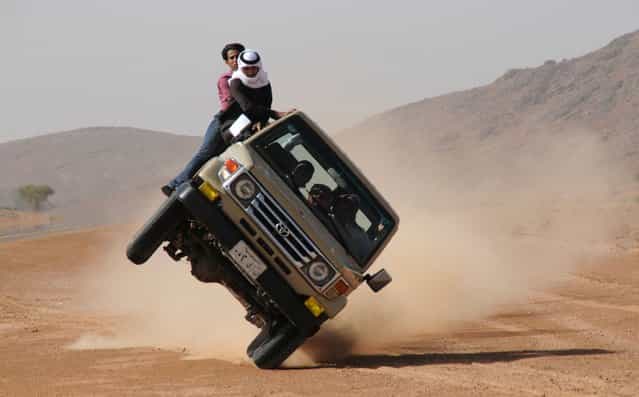 Saudi youths demonstrate a stunt known as [sidewall skiing] (driving on two wheels) in the northern city of Hail, in Saudi Arabia March 30, 2013. Performing stunts such as sidewall skiing and drifts is a popular hobby amongst Saudi youths. (Photo by Mohamed Al Hwaity/Reuters)