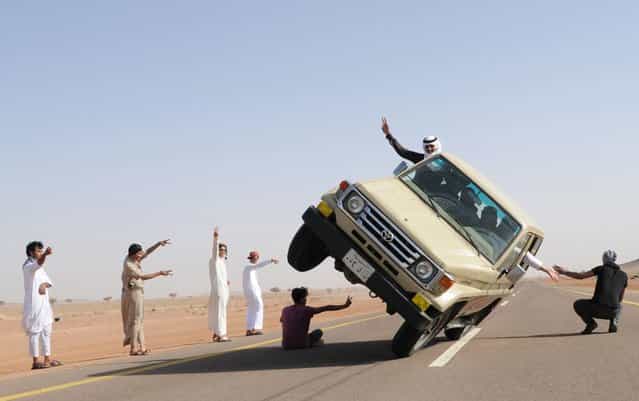 Saudi youths demonstrate a stunt known as [sidewall skiing] (driving on two wheels) in the northern city of Hail, in Saudi Arabia March 30, 2013. Performing stunts such as sidewall skiing and drifts is a popular hobby amongst Saudi youths. (Photo by Mohamed Al Hwaity/Reuters)