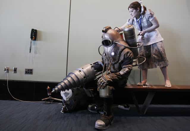 Aly Ilyadias helps Will Patriquin with his costume, both of them dressed as characters from the video game BioShock, at the PAX East gaming convention in Boston, Massachusetts, on March 23, 2013. (Photo by Jessica Rinaldi/Reuters /The Atlantic)