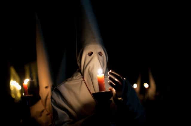 A penitent protects the flame of a candle during the Holy Week procession of the Cofradia Jesus Yacente on March 29, 2013 in Zamora, Spain. (Photo by Pablo Blazquez Dominguez /The Atlantic)