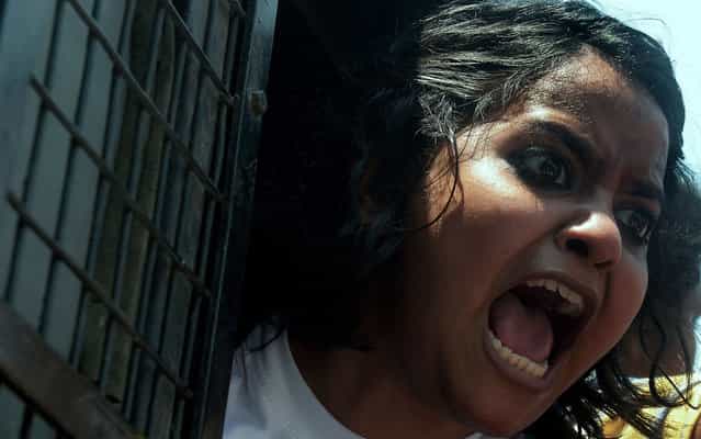 An activist from a leftist students’ union shouts slogans against Gujarat Chief Minister Narendra Modi from a police van outside the venue of his meeting with business leaders in Kolkata, on April 9, 2013. Police arrested students and other protesters and tightened security around the venue. (Photo by Dibyangshu Sarkar/AFP Photo)