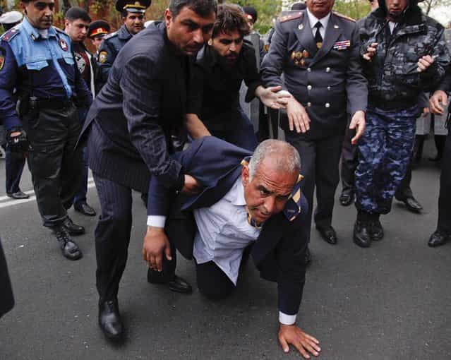 Armenian election runner-up Raffi Hovanessian is helped up after he fell during clashes between his supporters and police in Yerevan, on April 9, 2013. Armenian President Serge Sarkisian has been sworn in for another five-year term to lead the small former Soviet republic amid street protests by his opponents. (Photo by Tigran Mehrabyan/PanARMENIAN)