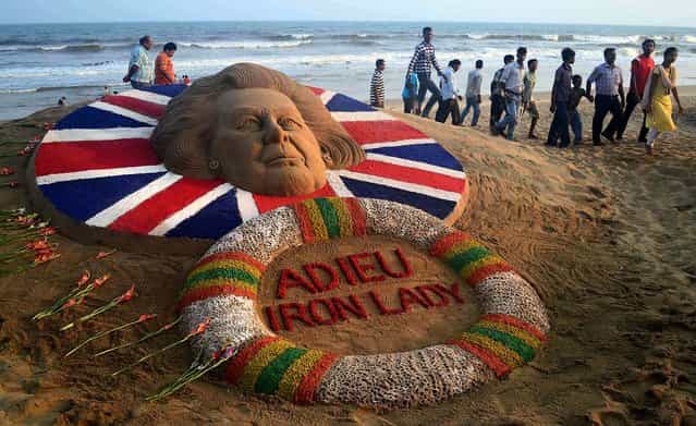 People walk past a sand sculpture of Margaret Thatcher, made by Sudarshan Pattnaik, in Puri, about 42 miles from the southeastern Indian temple city of Bhubaneswar, on April 9, 2013. (Photo by Biswaranjan Rout/Associated Press)
