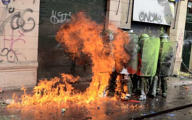 Students clash with riot police during a protest to demand Chilean President Sebastian Pinera's government to improve the public education quality, in Santiago, on April 11,2013. (Photo by Pablo Tapia/AFP Photo)