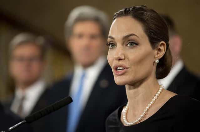 Flanked by G8 Foreign Ministers, Angelina Jolie, in her role as UN envoy, talks during a news conference regarding sexual violence against women in conflict, during the G8 Foreign Ministers meeting in London, on April 11, 2013. (Photo by Alastair Grant/Associated Press)