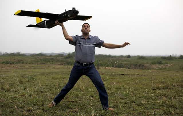 Remo Peduzzi, managing director of ResearchDrones LLC Switzerland, prepares to fly a drone at the Kaziranga National Park at Kaziranga in Assam state, India, on April 8, 2013. Wildlife authorities used drones on Monday for aerial surveillance of the sprawling natural game park to protect the one-horned rhinoceros from armed poachers. The drones are equipped with cameras and will be monitored by security guards, who find it difficult to guard the whole 185-square mile reserve. (Photo by Anupam Nath/Associated Press)