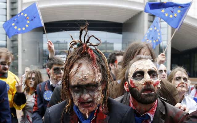 Demonstrators, including members of the European Parliament (MEP), dressed as zombies, dance to the music of Michael Jackson’s [Thriller] while participating in a flash-mob in front of the EU Parliament in Brussels. The flash-mob was organized in protest against possible EU-India free trade agreements that could endanger access to medicines, organisers said. (Photo by Francois Lenoir/Reuters)