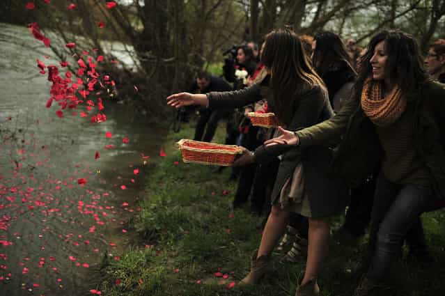 Female gypsy people throw flower petals into the Arga River in honor of their ancestors on the Day of the Gypsy, in Pamplona northern Spain, on Monday, April 8, 2013. (Photo by Alvaro Barrientos/AP Photo)