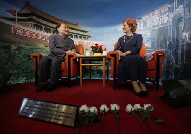 Flowers are laid by staff members in front of the wax statue of former British Prime Minister Margaret Thatcher, right, following her death in an exhibition center in Shenzhen, China Tuesday, April 9, 2013. Margaret Thatcher, the combative [Iron Lady] who infuriated European allies, found a fellow believer in Ronald Reagan and transformed her country by a ruthless dedication to free markets in 11 bruising years as prime minister, died Monday, April 8, 2013. She was 87 years old. The wax statue at left is of former Chinese leader Deng Xiaoping. (Photo by in Cheung/AP Photo)