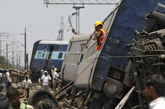 A rescue worker stands on a derailed coach at the site of a train accident near Arakkonam in the southern Indian state of Tamil Nadu April 10, 2013. One person was killed and dozens were injured after a passenger train derailed in Tamil Nadu, local media reported on Wednesday. (Photo by Babu/Reuters)