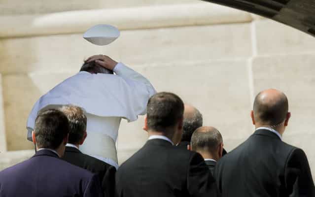 A gust of wind blows the Pope's Francis hat, on April 10, 2013. (Photo by Alessandra Tarantino/AP Photo)