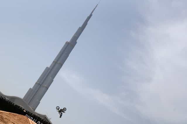 A motocross rider shows his skills during a training session outside Burj Khalifa on the eve of the 2013 Red Bull X-Fighters World Tour in the Gulf emirate of Dubai on April 11, 2013. (Photo by Marwan Naamani/AFP Photo)